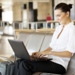 young woman using laptop computer at airport