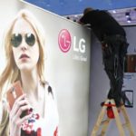 A worker makes adjustments at the booth of LG company at the IFA Electronics show in Berlin